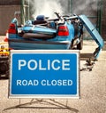 Police road closed sign in front of burning car wreckage Royalty Free Stock Photo